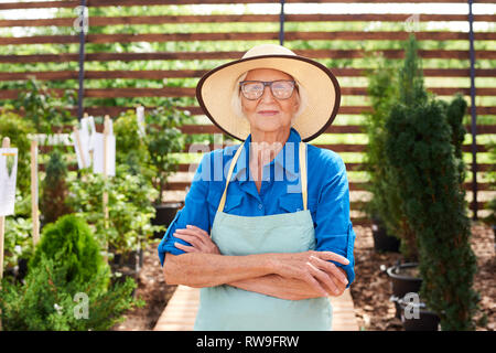 Senior giardiniere indossando cappello di paglia Foto Stock