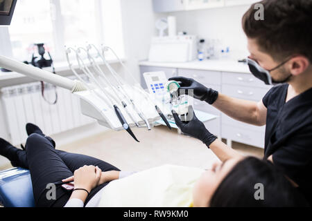 L'uomo dentista holiding dentiera sbadiglio per demonstarion in clinica dentale Foto Stock