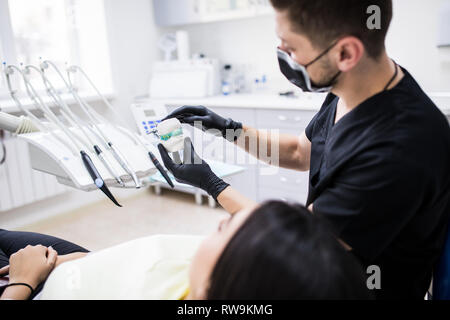 L'uomo dentista holiding dentiera sbadiglio per demonstarion in clinica dentale Foto Stock