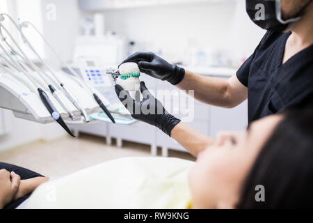 L'uomo dentista holiding dentiera sbadiglio per demonstarion in clinica dentale Foto Stock