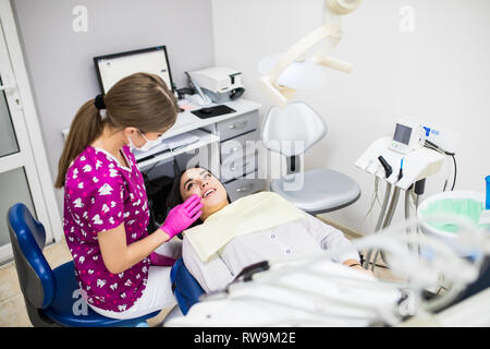 Panoramica della carie dentaria prevenzione.donna alla poltrona del dentista durante una procedura dentale. Bella Donna sorriso vicino. Sorriso sano. Bella Foto Stock