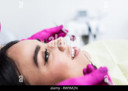 Giovane donna avente dental check-up in studio dentistico, sorridente, guardando la fotocamera. Foto Stock