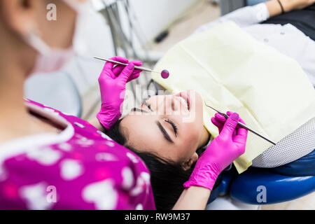 Giovane donna avente dental check-up in studio dentistico, sorridente, guardando la fotocamera. Foto Stock