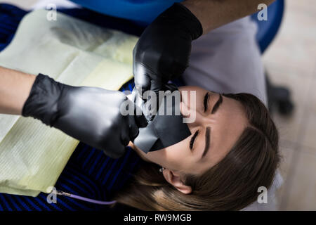 Un lattice piastra atta ad isolare il dente da trattare dal resto della cavità orale durante il trattamento. Dentisti preparare un dente per installare un mare Foto Stock