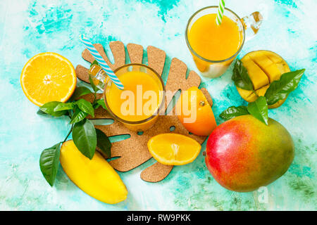 Estivo rinfrescante di mango e citrus spremuta fresca. Concetto di cibo vegetariano, fresche vitamine. Vista superiore piatta sullo sfondo dei laici. Foto Stock