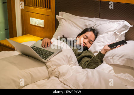 Asian imprenditrice stanco e dormire su hotel bed Foto Stock