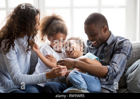 Sorridente famiglia nero divertirsi a casa con bambini piccoli Foto Stock