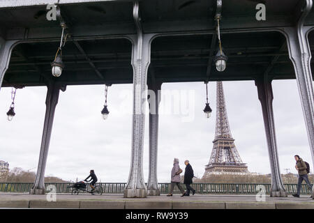 Persone di passaggio lungo il Bir Hakeim bridge con una vista della Torre Eiffel a Parigi, Francia. Foto Stock