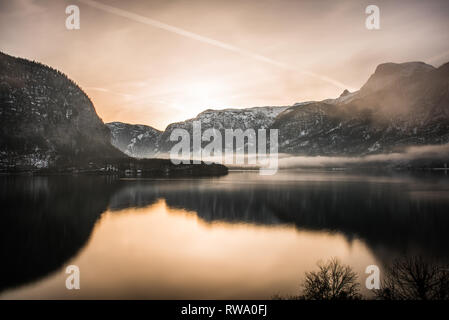 Esposizione lenta photo acquisisce l'alba alba e riflessioni durante l ora d'oro oltre il lago Hallstatt in Austria Foto Stock