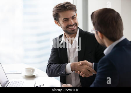 Soddisfatto happy businessman in tuta di handshake partner business rendendo deal Foto Stock