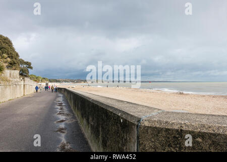 La gente fuori e circa una domenica pomeriggio, passeggiate lungo la spiaggia di Avon, Mudeford, Dorset, Regno Unito Foto Stock