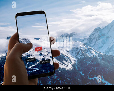 La realtà aumentata (AR) la tecnologia dell informazione è visualizzata su uno smartphone nelle Alpi a guida e visualizza le informazioni sul caf, piste da sci e restaur Foto Stock