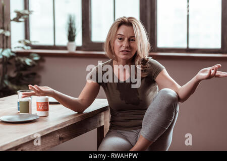 Ubriaco bionda donna spandere acqua sulla t-shirt Foto Stock