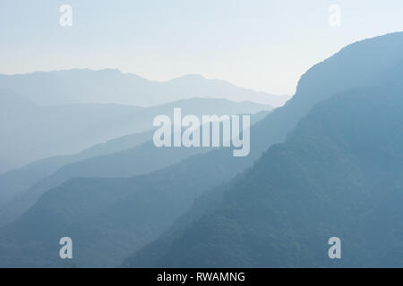 Più coperta di foresta misty blue hills al mattino Foto Stock