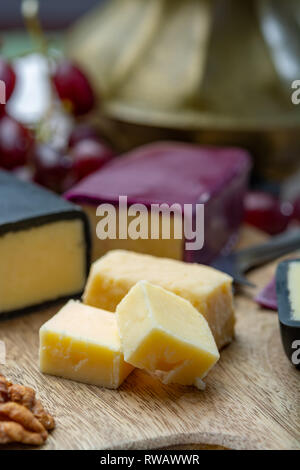 Mini nero e rosso scuro cerata formaggi cheddar realizzato da ovest paese latte e secolare e metodi in Inghilterra da vicino Foto Stock