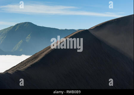 Bel mattino paesaggio di montagna con un irriconoscibile escursionisti sul ripido tratto del bordo del cratere ridge. Foto Stock