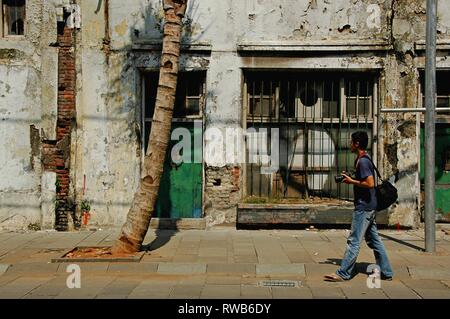 Un maschio di fotografo è a piedi in strada di Kota Tua Jakarta, Indonesia. Foto Stock