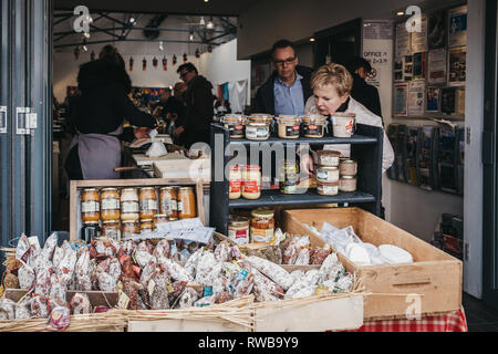 London, Regno Unito - 2 Marzo 2019: persone navigando il cibo in un mercato in stallo a Hampstead centro comunitario nel mercato Hampstead, un affluente area residenziale di Foto Stock