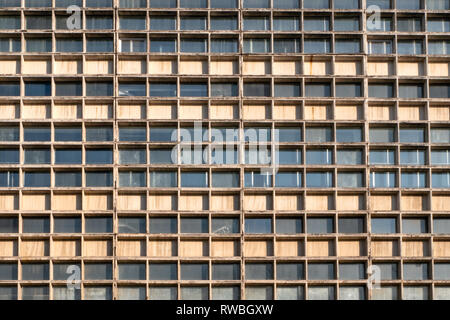 Facciata del grattacielo. Molte finestre di geometrico. Parete con un sacco di identiche righe della finestra. Close-up. Foto Stock