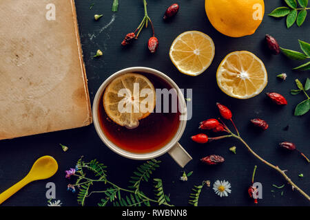 La medicina di erbe laici flat top view con tazza di caldo anca rosa tea e fetta di limone Foto Stock