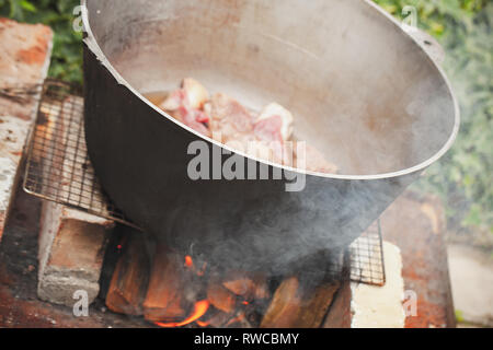 Agnello con verdure a fettine ebollizione in un calderone. La preparazione esterna di zuppa Chorba Foto Stock