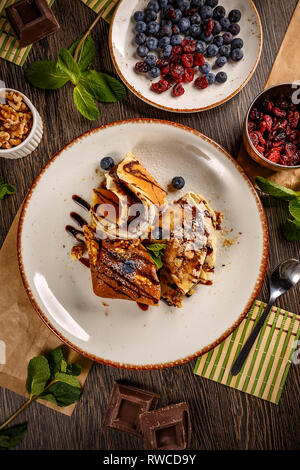 Crepes con cioccolata spalmabile e noci. In casa crespelle sottili per dessert Foto Stock