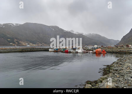 Piccole imbarcazioni, tra cui una nave ormeggiata scialuppa di salvataggio in un piccolo uomo di pietra reso porto vicino Maloy Town, Vagsoy, Norvegia. Foto Stock