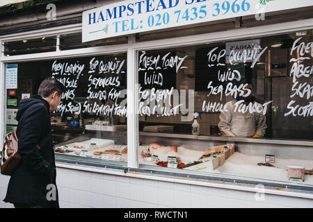 London, Regno Unito - 2 Marzo 2019: persone dal pescivendolo stallo a Hampstead centro comunitario nel mercato Hampstead, un affluente area residenziale di Londra favou Foto Stock