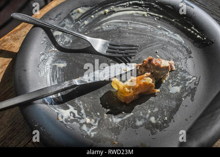 Una piastra sporca dopo un pasto con una forchetta e coltello Foto Stock