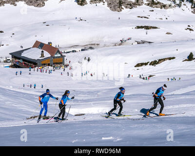Quattro giovani di livello professionale fondisti di fronte al El Ferial rifugio alpino Foto Stock