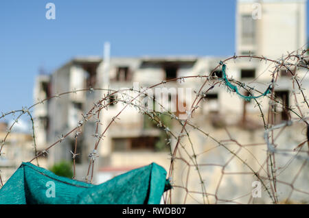 Filo spinato in fron di edifici abbandonati si trova nella zona di buffer nel centro di Nicosia Foto Stock