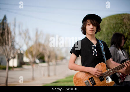 Ragazzo adolescente a suonare la chitarra durante la pratica di banda. Foto Stock