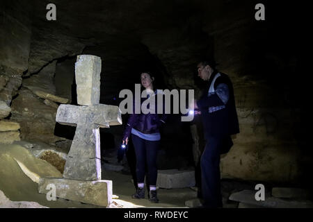 Guida spiega il ruolo di una chiesa sotterranea nelle catacombe trovati sotto Odessa, Ucraina Foto Stock