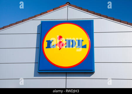 Il segno di Lidl e il logo contro un luminoso cielo blu sulla parte anteriore del negozio Lidl a Farnham, Surrey. Foto Stock