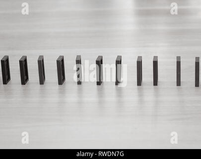 Close up. Domino chips sono costruiti in una fila sul desktop imprenditore Foto Stock