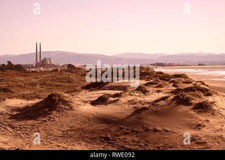 Xx Febbraio, 2019 Capitola, CA, Stati Uniti d'America luce della sera scende oltre le dune a Moss Landing, guardando verso la PG&E Power station Foto Stock