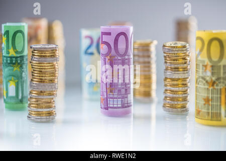 Arrotolate le banconote e le monete in euro torri impilati in altre posizioni. Foto Stock