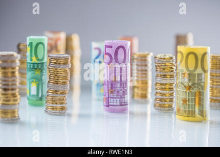 Arrotolate le banconote e le monete in euro torri impilati in altre posizioni. Foto Stock