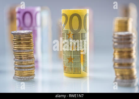 Arrotolate le banconote e le monete in euro torri impilati in altre posizioni. Foto Stock