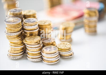 Le banconote e le monete in euro togetger sul tavolo bianco - close-up Foto Stock