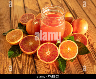 Composizione luminosa con arance rosse e succo di frutta di sangue fresco di arance, colpo all'aperto sotto il sole Foto Stock