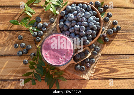 Frullato di mirtilli con bacche fresche sul rustico sfondo in legno.Vista Superiore Foto Stock