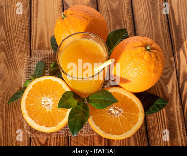 Succo di arancia con frutti maturi. Brillante composizione all'aperto sotto il sole Foto Stock