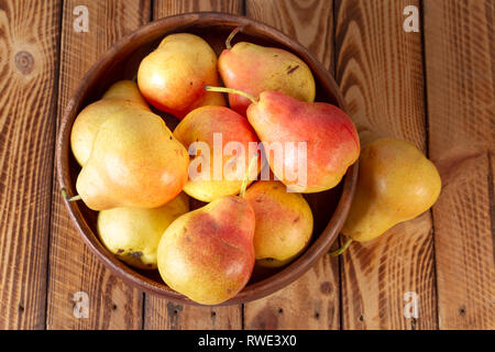 Chiudere la Coppa di pere mature pere biologiche legno rustico vista superiore Foto Stock