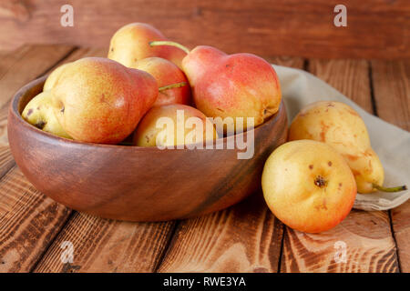 Chiudere le pere ciotola tazza di pera matura luminoso rustico in legno di composizione Foto Stock