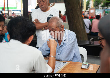 24.02.2019, Singapore, Repubblica di Singapore, in Asia - Gli uomini stanno giocando a scacchi cinesi accanto al Dente del Buddha reliquia tempio in Chinatown. Foto Stock