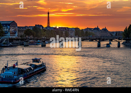 Parigi e la Senna che scorre sotto il Pont des Art al tramonto, con la Torre Eiffel in lontananza, Parigi, Francia Foto Stock