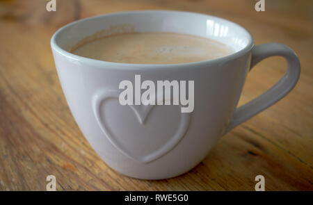 Tazza da caffè con forma di cuore, focus è il cuore al centro della tazza con profondità di campo per le altre aree, dando un leggero effetto sfocato. Foto Stock
