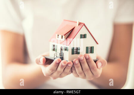 Le mani della giovane donna azienda modello di casa Foto Stock