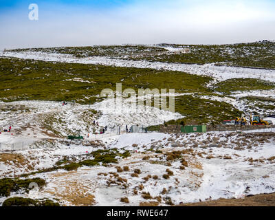 Irriconoscibile persone scivolando sul ghiaccio in un pendio in montagna su La Covatilla, Bejar (Salamanca) Foto Stock